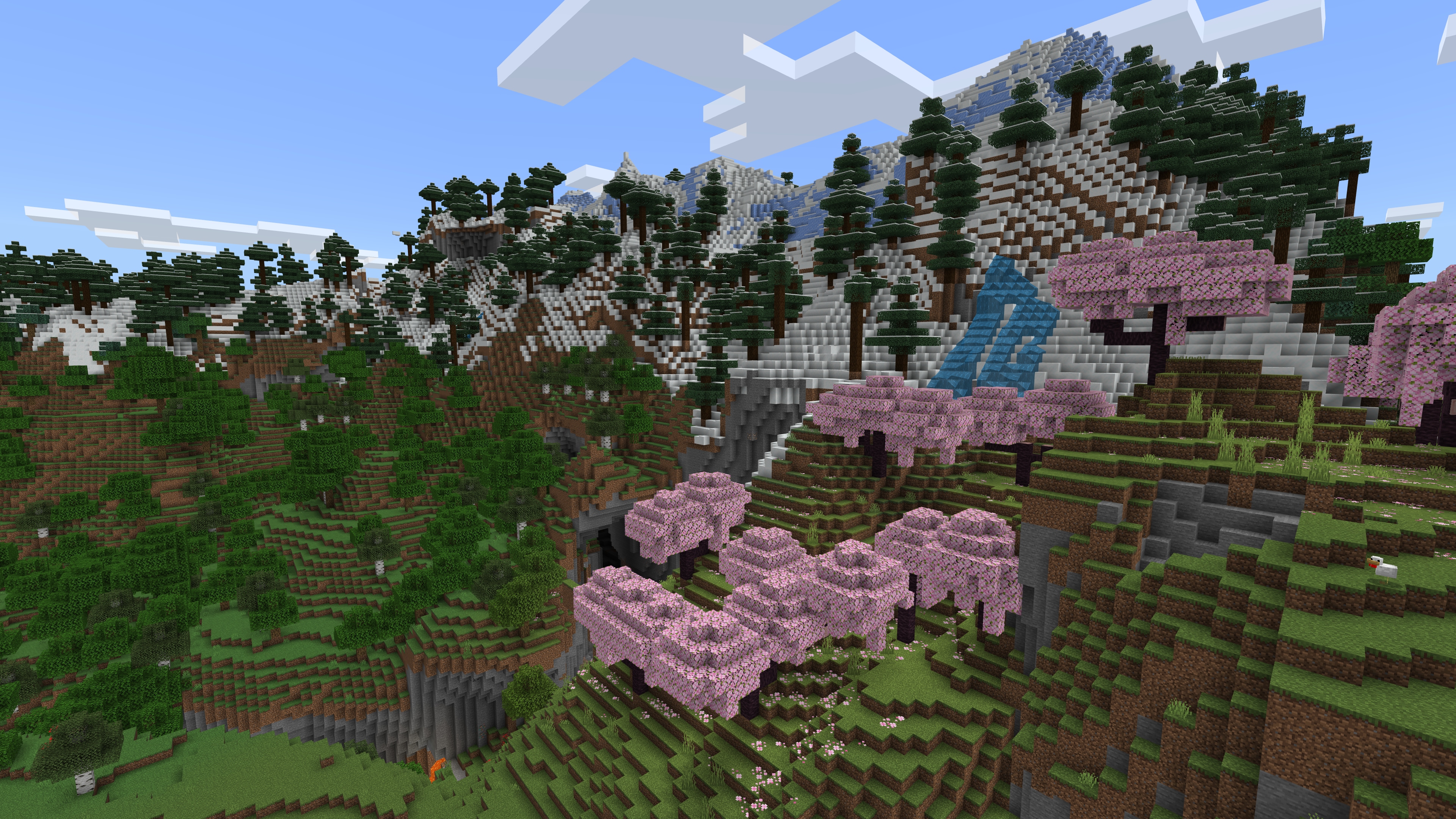 La cima de una montaña cubierta de nieve en Minecraft coronada por robles, pinos y cerezos.