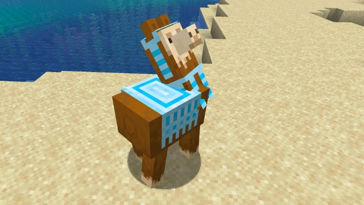 A Minecraft llama standing on a beach, wearing a carpet on its back.